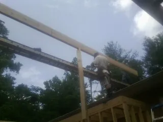 Carpenter setting a ridge beam over a new addition frame — Ice Dam Removal by Roofing Brothers in Terry