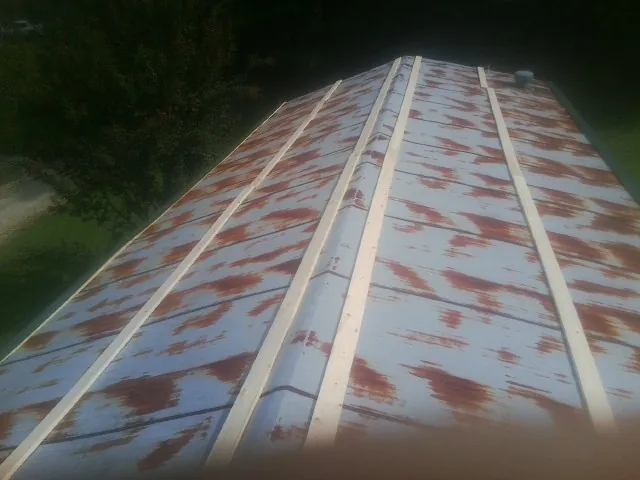 Rusted metal roof panels with new wood purlins before replacement — Storm Damage Roof Repair in Terry by Roofing Brothers