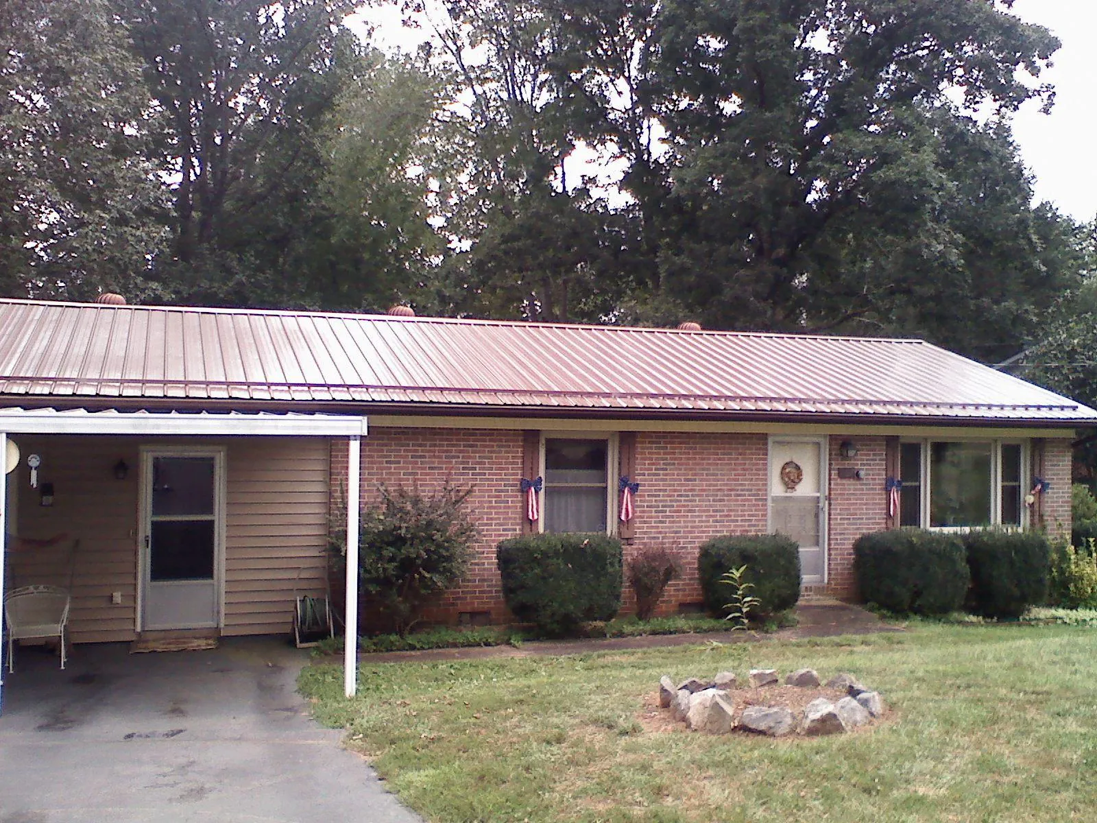 Bronze metal roof and carport on a brick ranch home — Roof Repair work by our crew in Terry